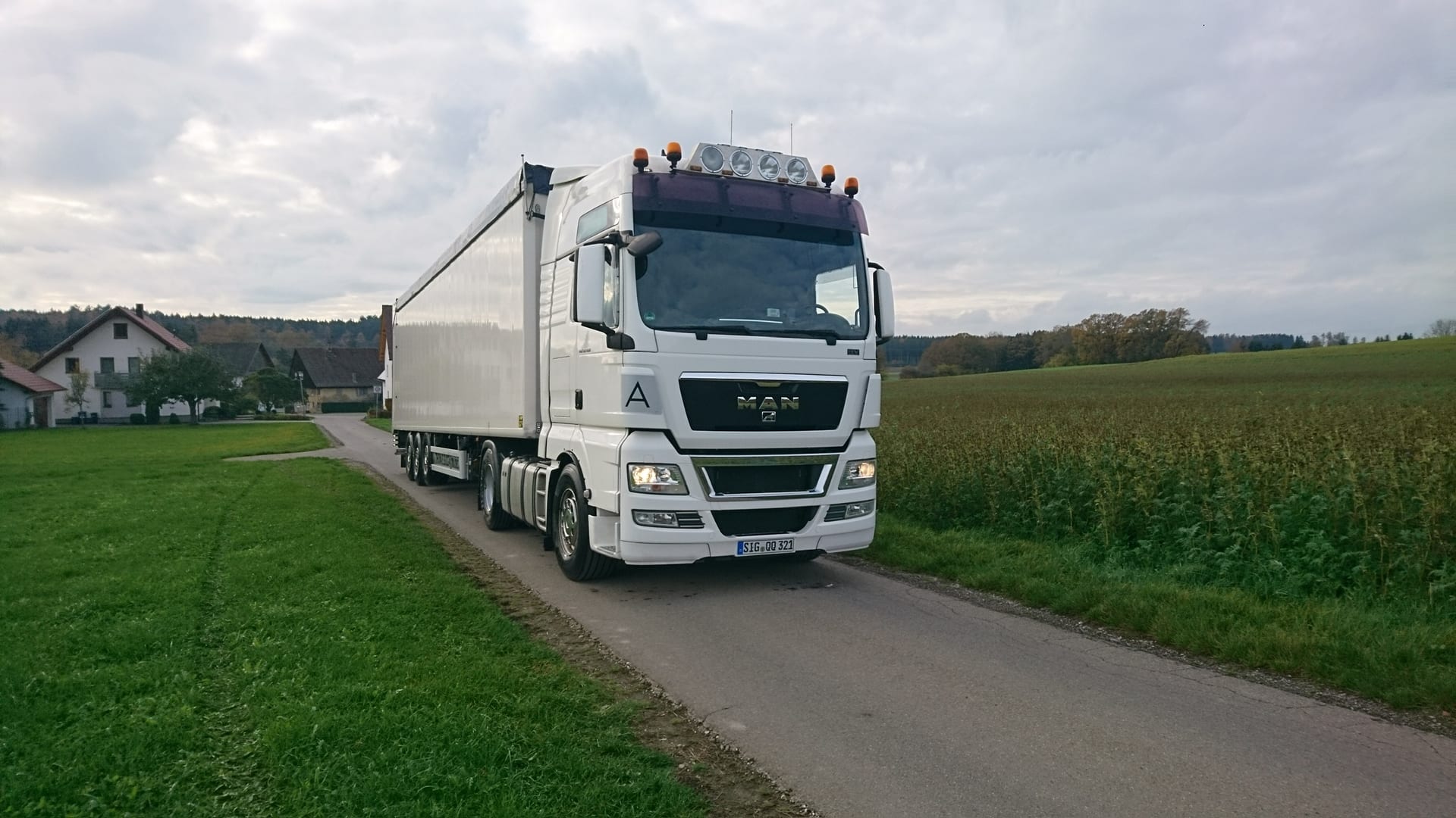 Weißer MAN-Sattelzug von SUGG auf einer Landstraße durch die oberschwäbische Landschaft